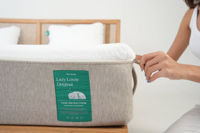 Unzipping the removable cover of a Lazy Lowie mattress for washing