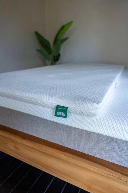 A natural latex mattress topper on a made bed